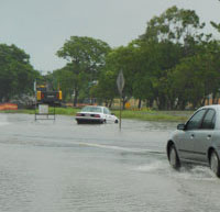 Paradise Street, Mackay, flooded and car in ditch